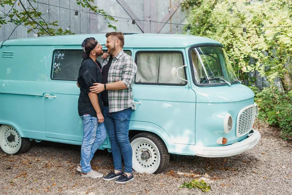 Porträtt av ett homosexuellt par som kramas nära en blå skåpbil — Stockfoto