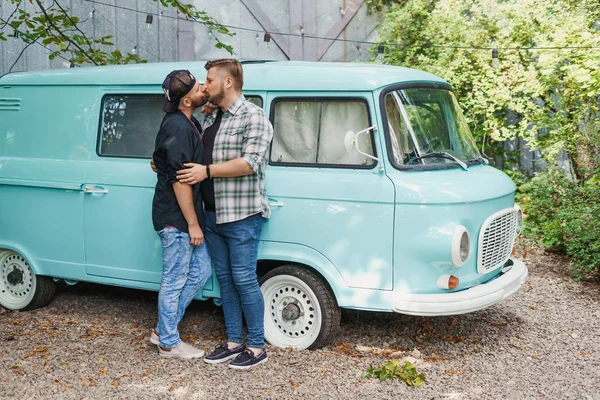 Gay paar zoenen, staan in de buurt van een ouderwetse blauwe auto van — Stockfoto