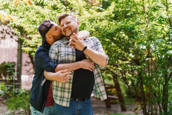 Parktaki eşcinsel çift. Genç bir adam erkek arkadaşına sarılıp öpüyor. — Stok fotoğraf