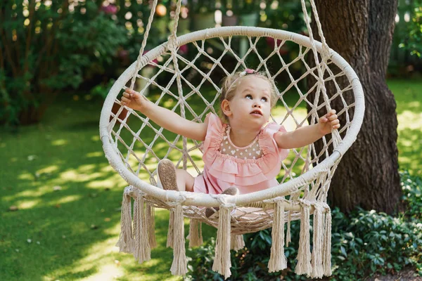 Kleines Mädchen auf einem schaukelnden Hängemattenstuhl im Park — Stockfoto