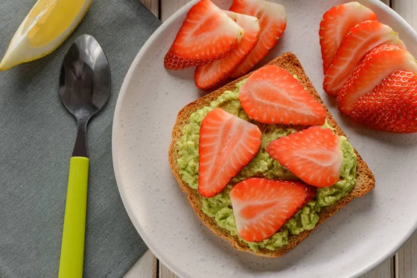 Toast with mashed avocado and strawberry slices