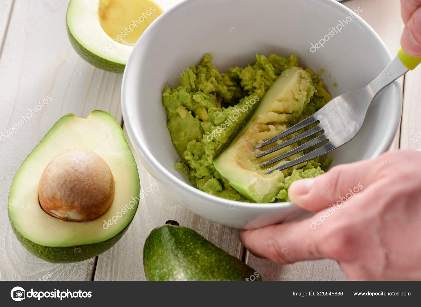 Mashing avocado with a fork. Vegan food Stock Photo by ©YGphoto 325546836