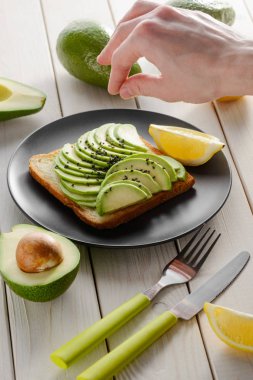 Avokado tostu pişiren adam. Mükemmel kahvaltı fikirleri.