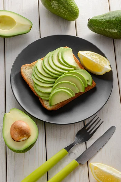 Tostadas con rodajas de aguacate verde y jugo de limón — Foto de Stock