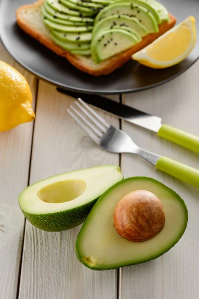 Половина авокадо на деревянном столе. Рецепт вегетарианской еды — стоковое фото
