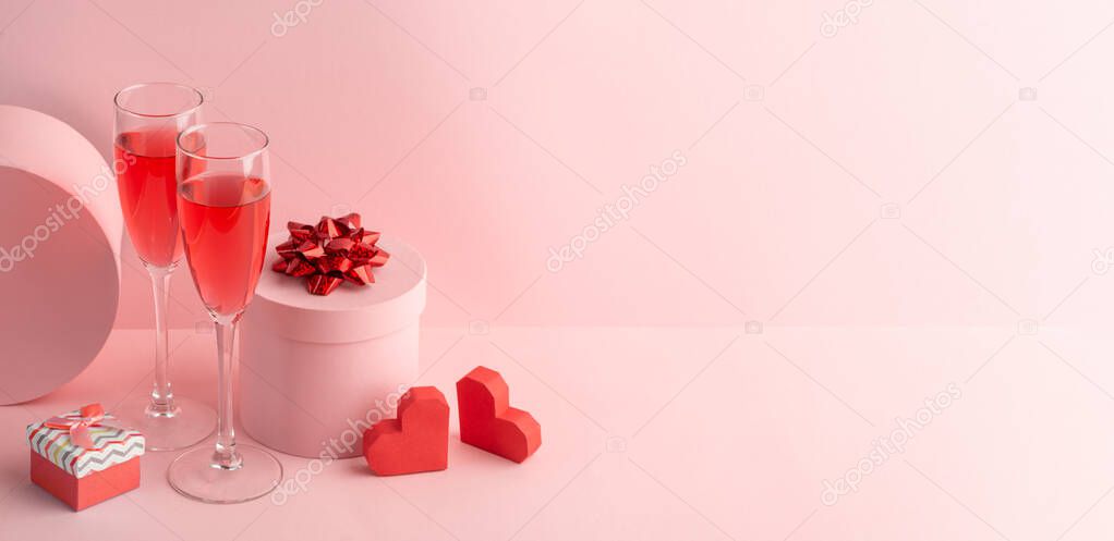 Round gift boxes, red hearts and glasses of sparkling wine on pink background