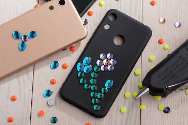 Black phone case decorated with rhinestone flower — Stock Photo, Image