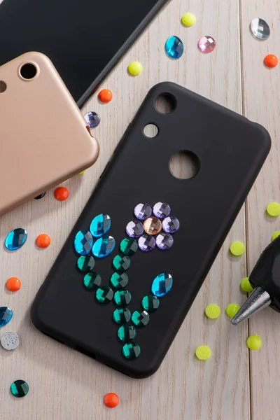 Black phone case with rhinestone flower art — Stock Photo, Image