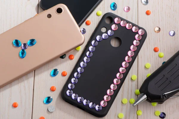 Attaching colorful rhinestones onto phone cases with a glue gun — Stock Photo, Image