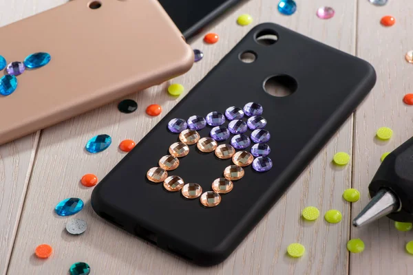 Phone cases decorated with rhinestones. House and flower art — Stock Photo, Image