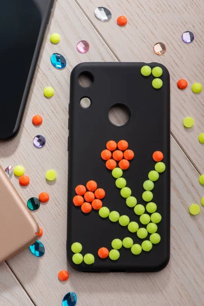 Black phone case with colorful bead flower — Stock Photo, Image