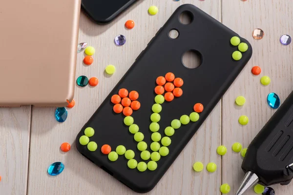 Black phone case adorned with flower bead art — Stock Photo, Image