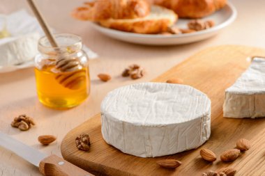 Ahşap kesme tahtasının üzerinde güzel beyaz bir kabuklu Camembert peyniri.