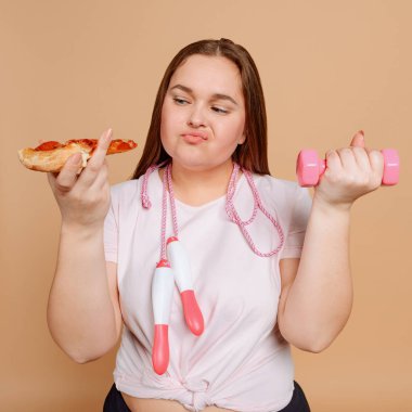 Kadın pizza ve egzersiz arasında seçim yapıyor. Fitness ve diyet konsepti