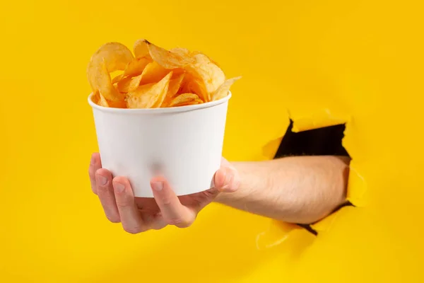 Mão segurando uma xícara de batatas fritas — Fotografia de Stock