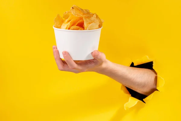 Mão dando uma xícara de batatas fritas — Fotografia de Stock