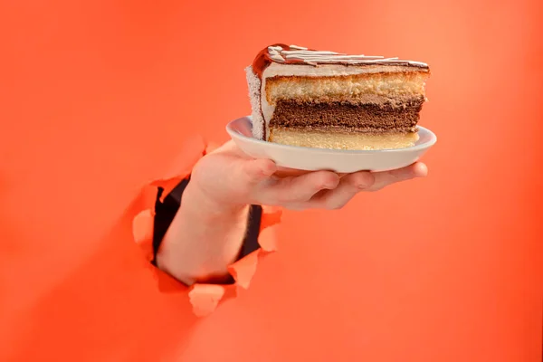 Mão dando um pedaço de bolo de chocolate — Fotografia de Stock
