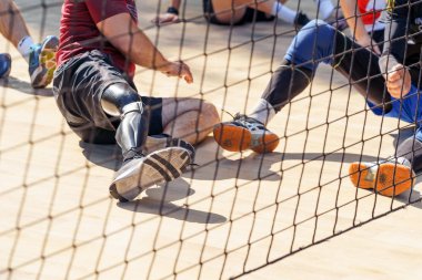 Ampüte olmuş atletler voleybol oynuyorlar. Protez bacaklı oyuncular