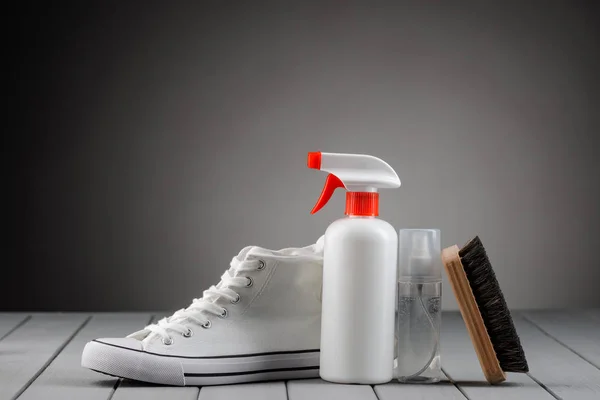 Cuidado y limpieza del calzado de lona en suelo de madera gris — Foto de Stock