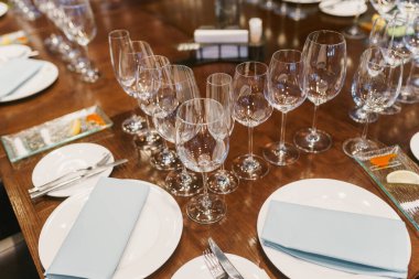 Empty glasses, white plates, cutlery and tableclothes
