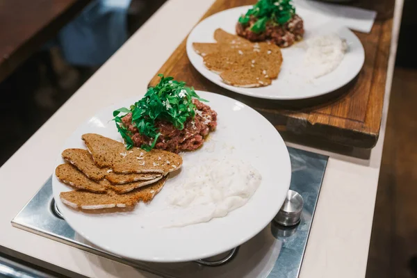 Bread slices, stack of fried tenderloin, arugula leaves and tartar sauce — Stockfoto