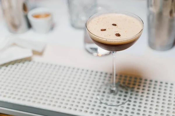 Glass of coffee cocktail with thick foam and coffee beans decoration