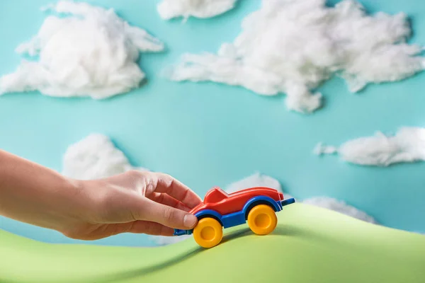 Kid playing with a toy car inside paper world — Stock Photo, Image