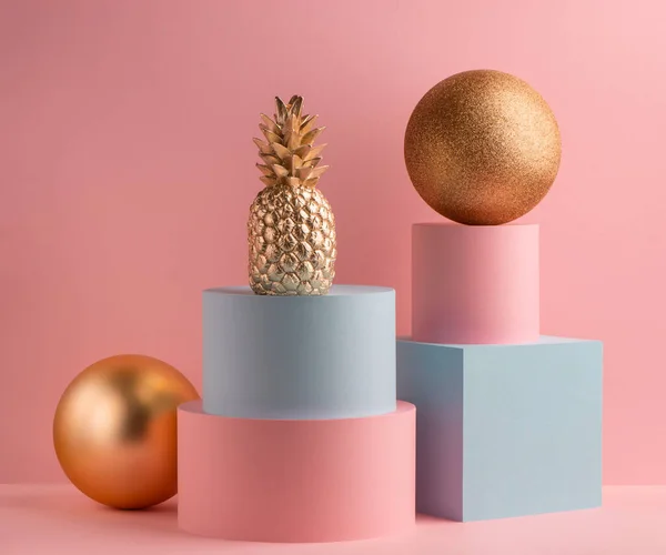 Abacaxi dourado, bola de glitter, cubo teal e caixa redonda rosa no fundo rosa — Fotografia de Stock