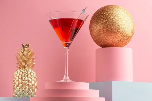 Glass of Manhattan cocktail, golden pineapple and glitter ball — Stock Photo, Image
