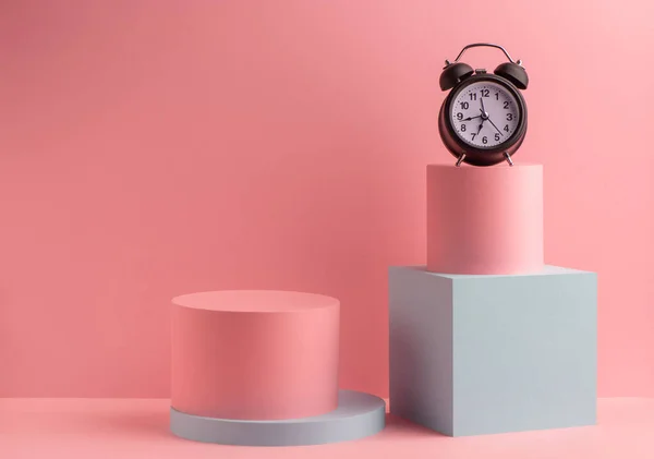 Reloj despertador negro sobre fondo rosa con cajas redondas y cubo —  Fotos de Stock