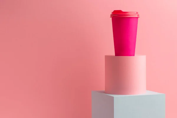 Taza de papel café brillante sobre fondo rosa con espacio para copiar —  Fotos de Stock