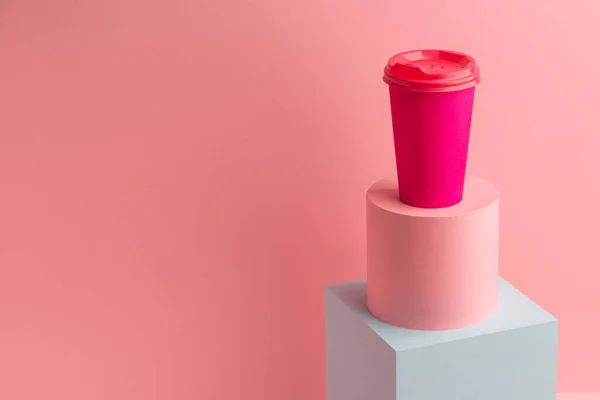 Taza de papel café brillante sobre fondo rosa con espacio para copiar —  Fotos de Stock