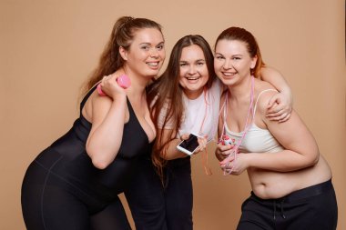 Bej arka planda güzel, büyük beden kadınlar.