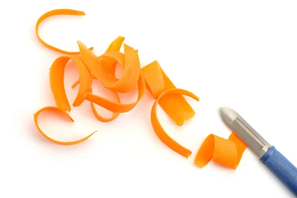 Aparas de cenoura e faca descascador no fundo branco — Fotografia de Stock