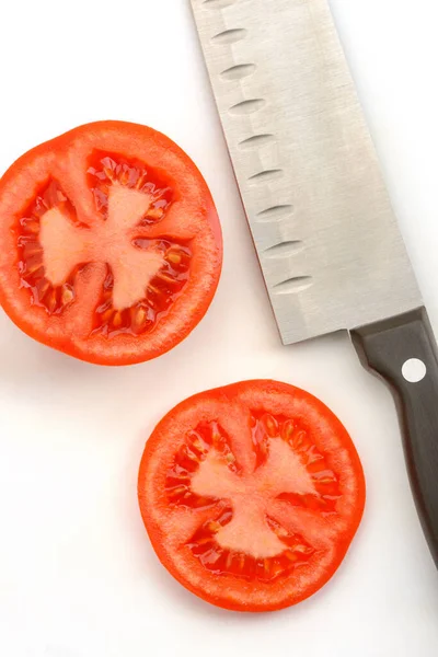 Tomatenscheiben und ein Santoku-Messer auf weißem Hintergrund — Stockfoto