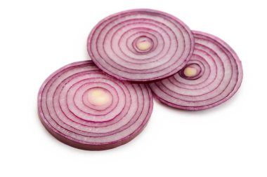 Beyaz arkaplanda birkaç dilim kırmızı soğan.