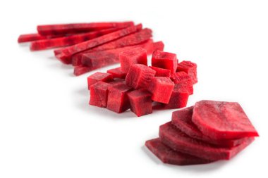 Beyaz arkaplanda kesilmiş pancar kökü yığınları