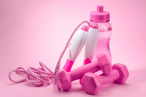 粉色背景的跳绳、水瓶和哑铃 — 图库照片