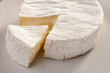 Brie peynirini yakından izle. Tekerlekten kesilmiş büyük bir parça.