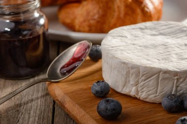 Brie peyniri ve yaban mersini ahşap kesim tahtasının üzerinde