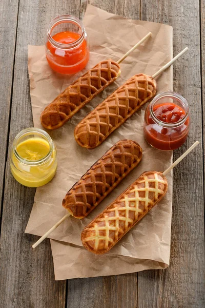 Corndogs, senap, ketchup och grill på trä bakgrund — Stockfoto