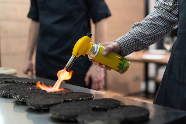 Homem usando uma tocha de cozinha para fazer pães mais crocantes — Fotografia de Stock