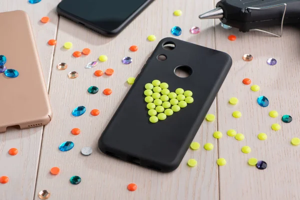 Black plastic case decorated with yellow bead heart — Stock Photo, Image