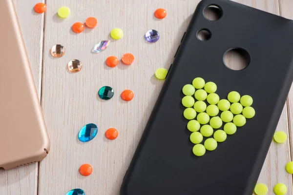 Black mobile phone case decorated with yellow bead heart — Stock Photo, Image