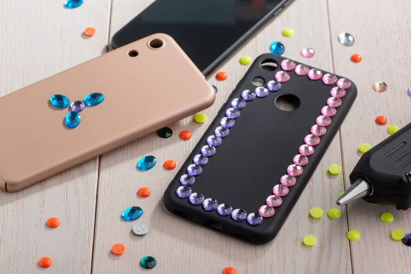 Phone cases being decorated with various rhinestones — Stock Photo, Image