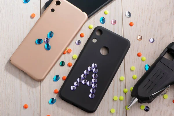 Attaching acrylic rhinestones onto phone cases with a glue gun — Stock Photo, Image