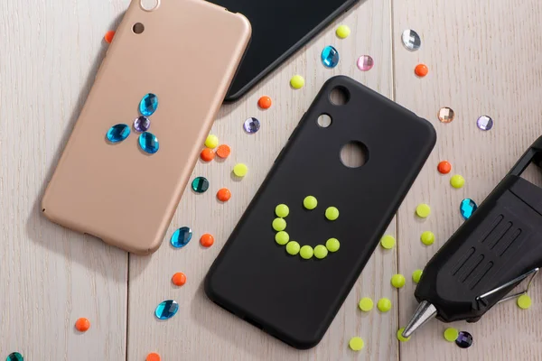 Phone cases being decorated with rhinestones and beads — Stock Photo, Image