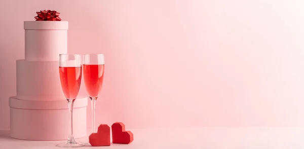 Stapel ronde geschenkdozen, glazen rode prosecco en twee hartjes — Stockfoto