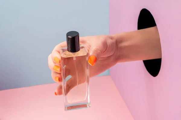 Primer plano en la mano de las mujeres que muestran una botella de perfume —  Fotos de Stock