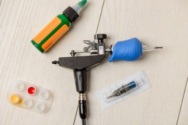 Döner dövme makinesini ve beyaz masadaki malzemeleri kapat.